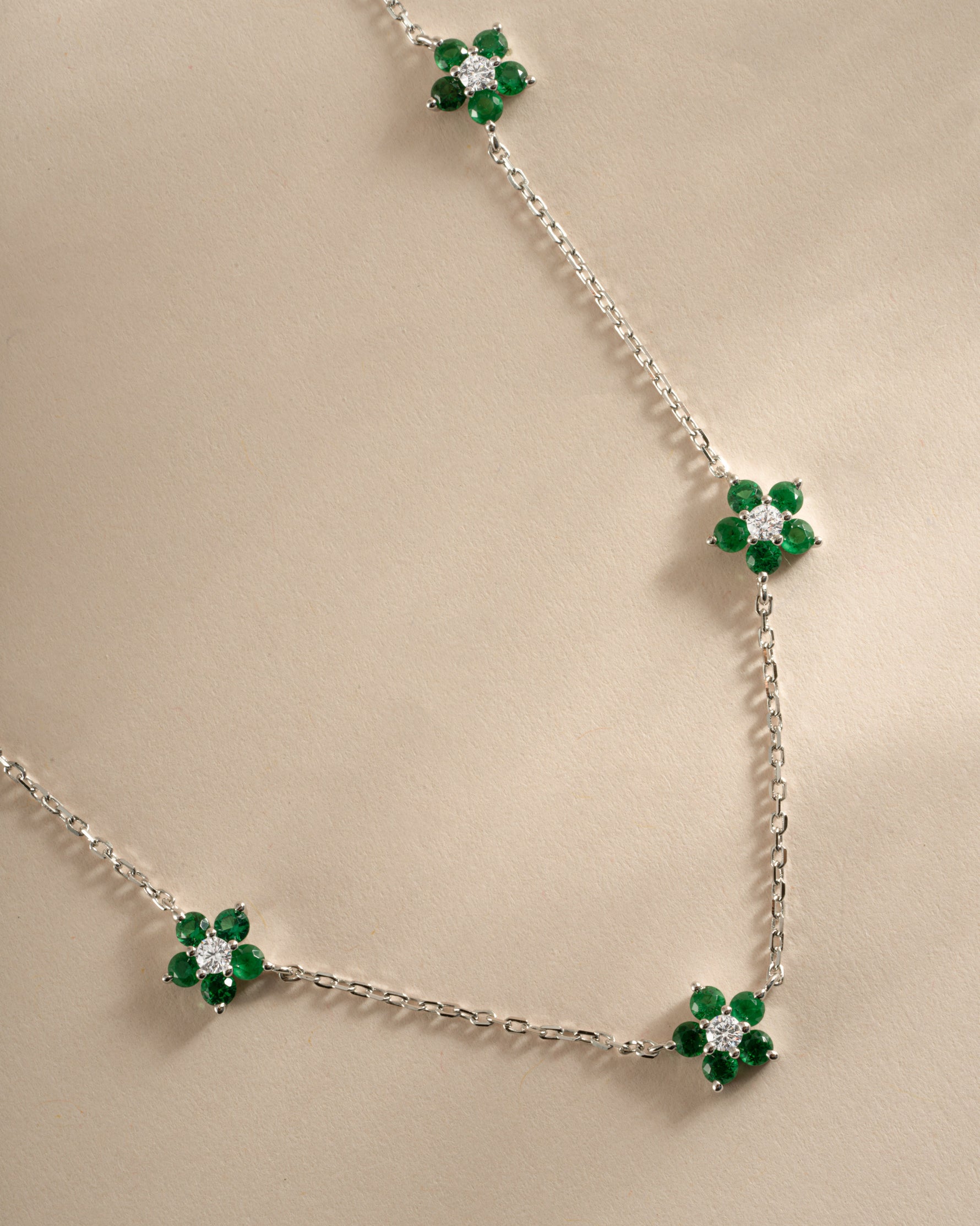 Close-up of SJ Faire Emerald Flower Necklace featuring a sterling silver chain and detailed emerald flower charm.