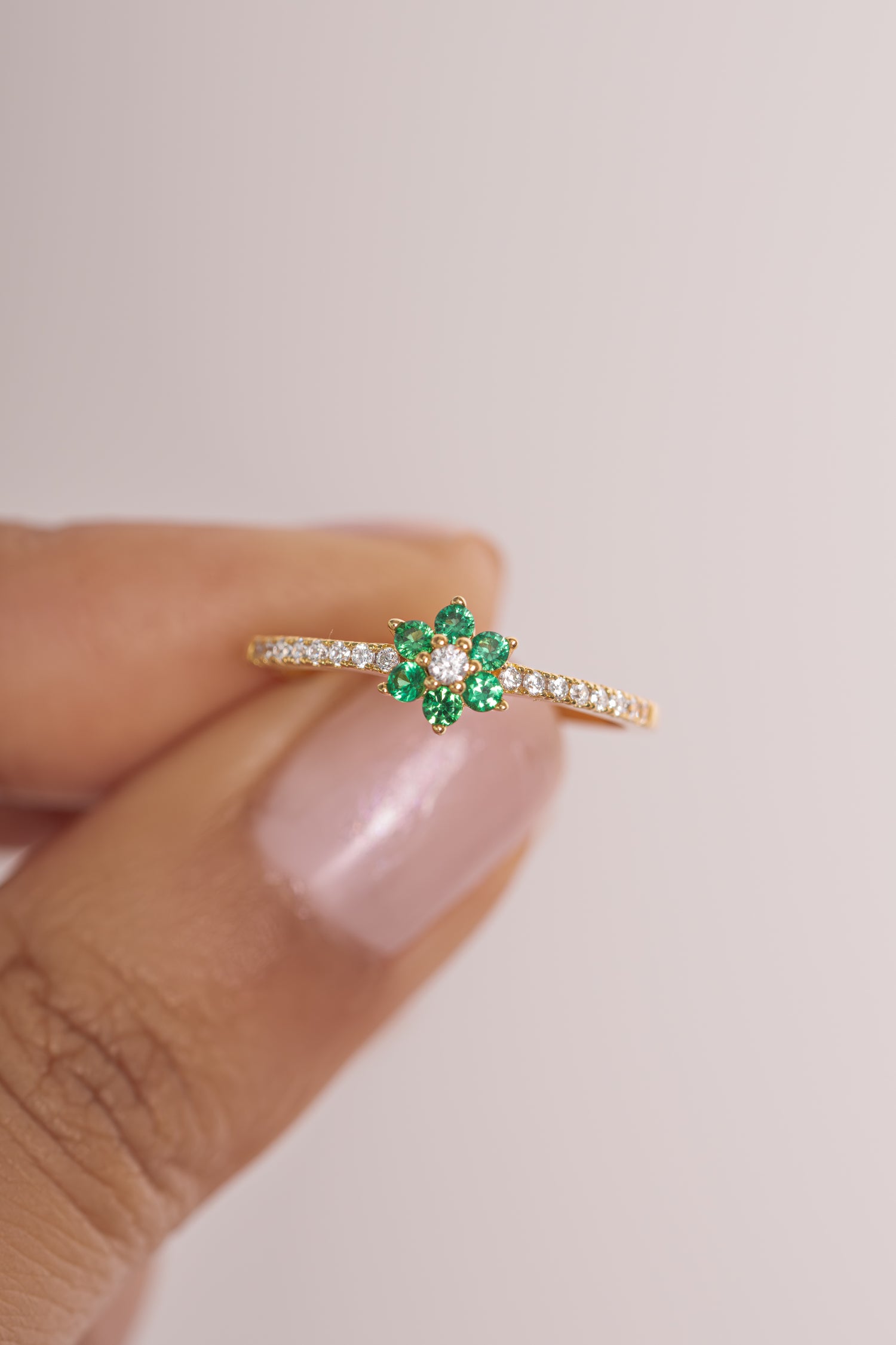 Close-up of Sami Jewels emerald flower ring, showcasing detailed gold band and vibrant green emerald flower design.