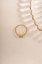 Gold ring featuring an emerald flower design from Sami Jewels, viewed from the top showing intricate gemstone details.