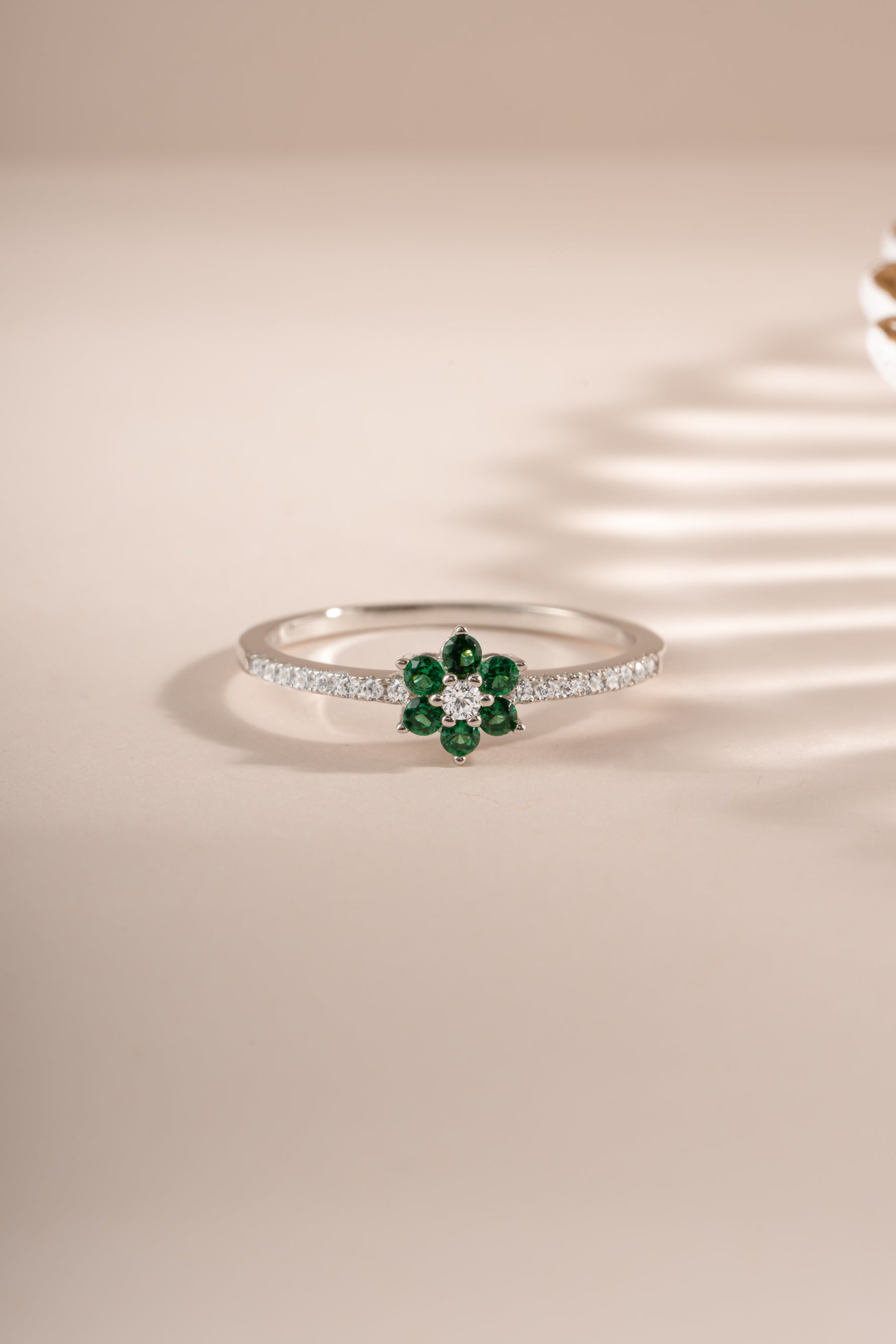 Sterling silver emerald flower ring by Sami Jewels, featuring a detailed floral design with vibrant green emerald center.