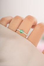 Sterling silver emerald flower ring by Sami Jewels featuring a detailed flower design with a prominent green emerald gemstone.