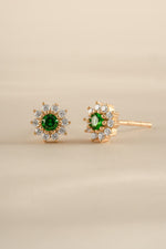 Sami Jewels emerald dainty flower stud earrings in gold, angled view showing detailed floral design and sparkling gemstone accents.