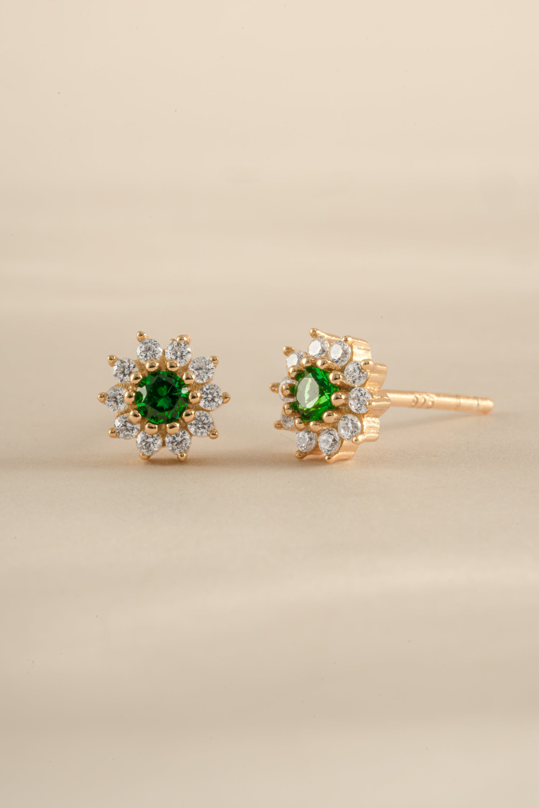 Sami Jewels emerald dainty flower stud earrings in gold, angled view showing detailed floral design and sparkling gemstone accents.