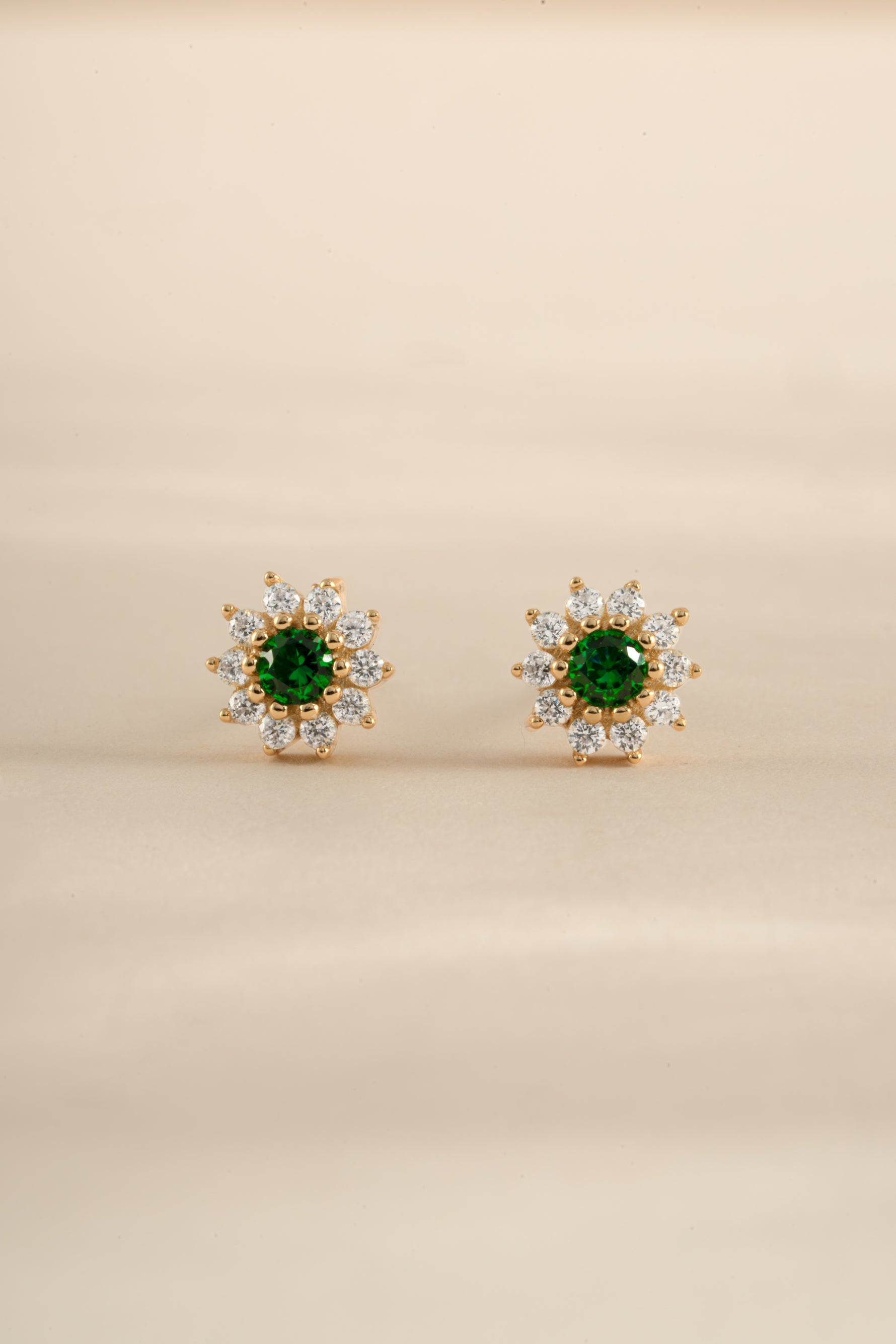 Gold emerald dainty flower stud earrings by Sami Jewels featuring delicate floral design and sparkling green gemstones.