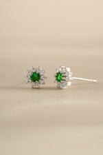 Silver Emerald Dainty Flower Stud Earrings by Sami Jewels featuring small floral design and vibrant green emeralds.