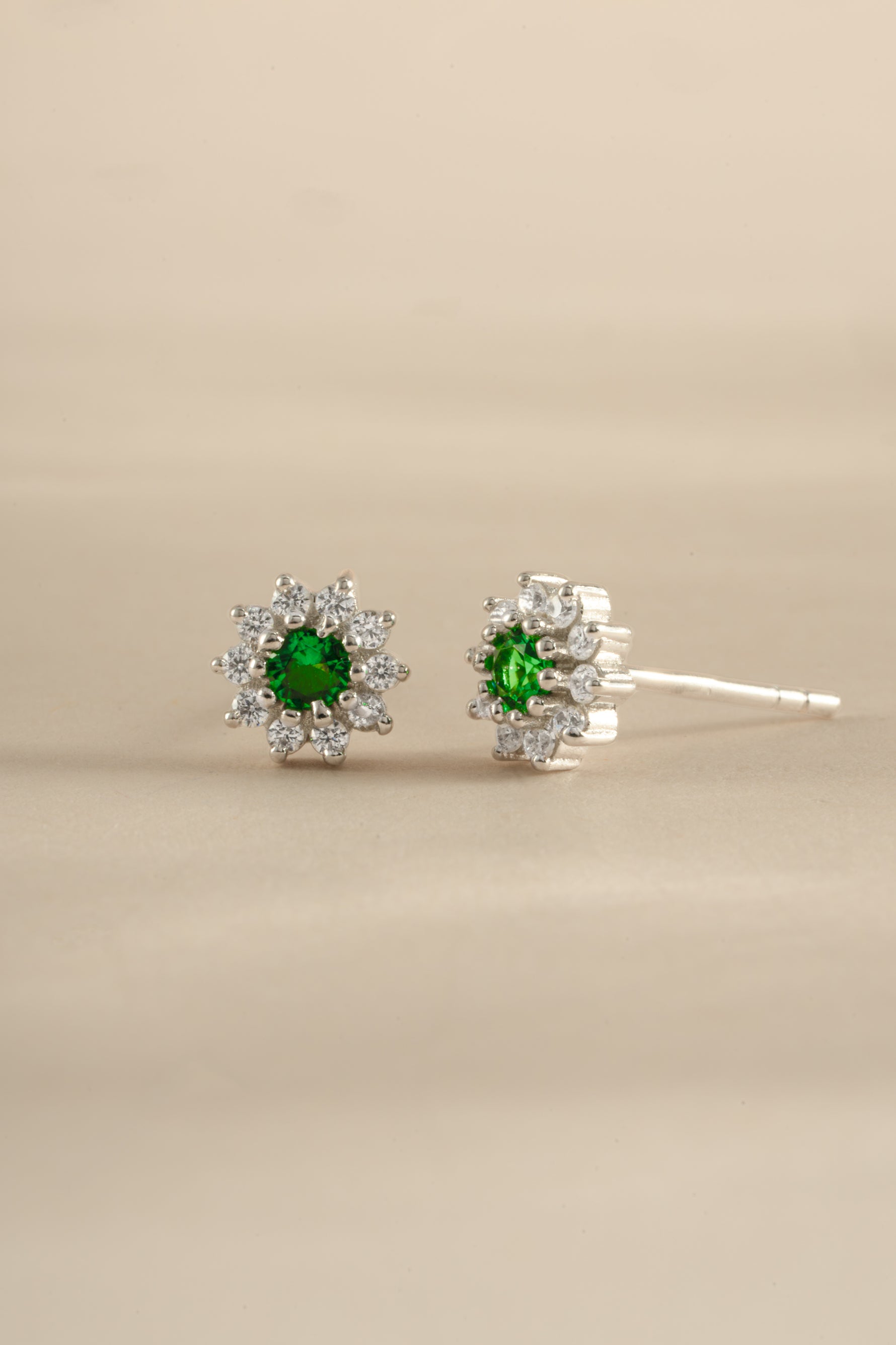 Silver Emerald Dainty Flower Stud Earrings by Sami Jewels featuring small floral design and vibrant green emeralds.