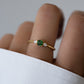 model wearing an emerald ring with a cushion stone and pear side stones