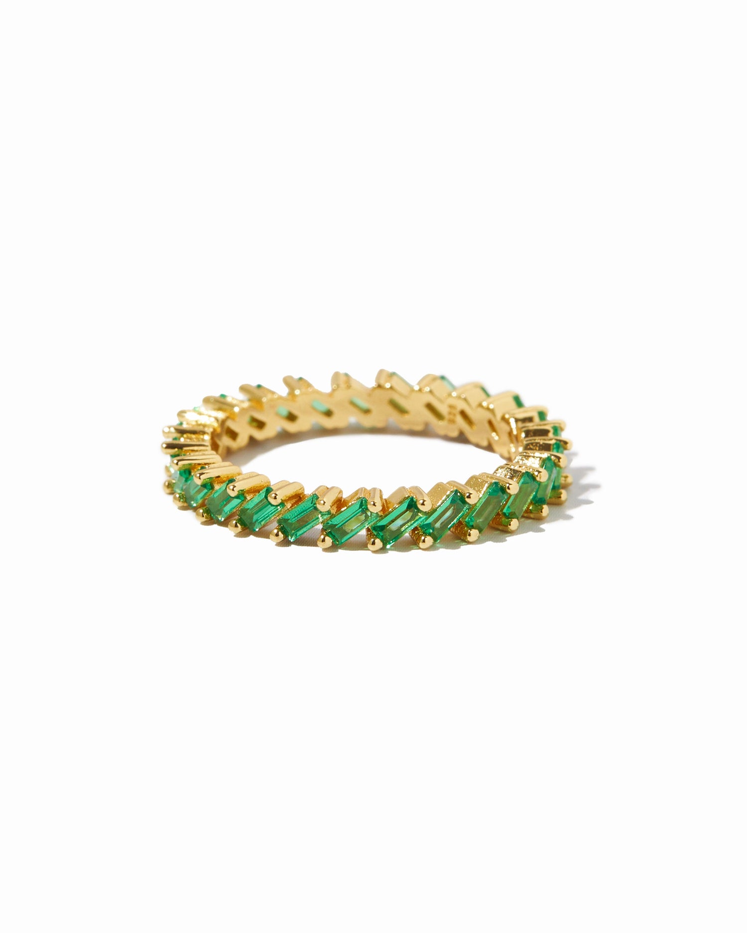 Gold Sami Jewels slanted emerald baguette ring featuring a sleek design on a white background.