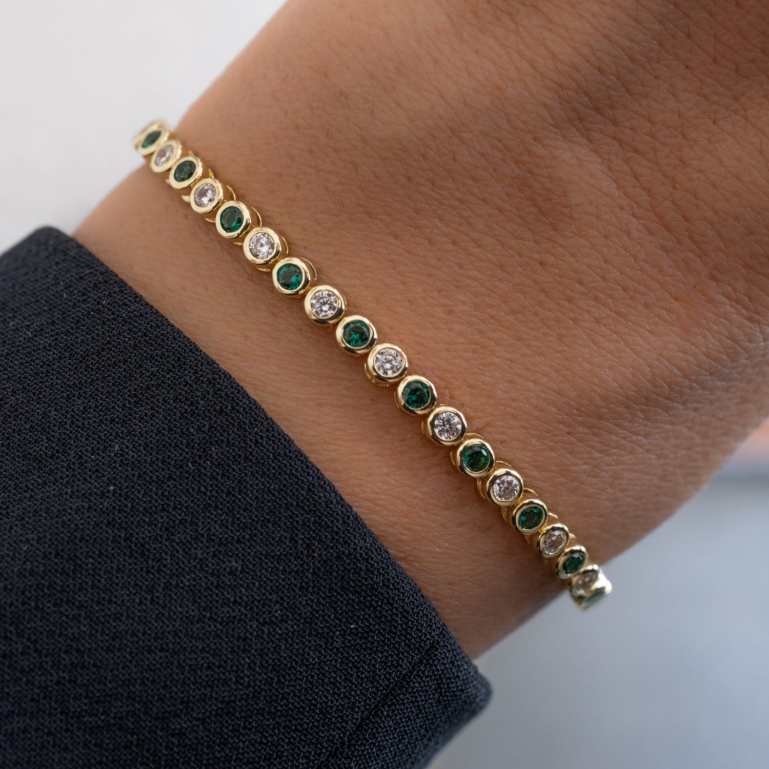 model wearing emerald green and white cz tennis bracelet
