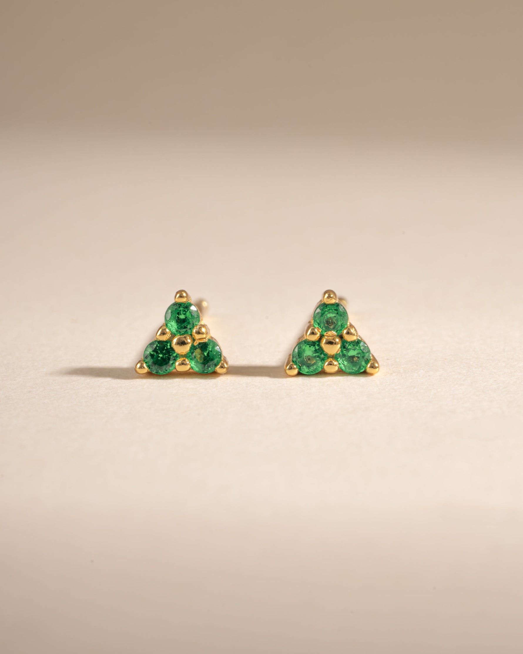 Sami Jewels Tiny Emerald 3 Stone Stud Earrings featuring three vibrant emerald gemstones set in gold, front view.