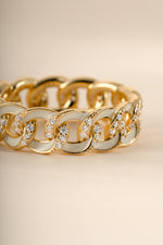 Close-up of a white enamel chain ring by Sami Jewels, showcasing the detailed white enamel design and gold chain accents.