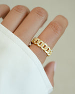 White enamel chain ring by Sami Jewels featuring a sleek gold-tone design, displayed on a model's finger.