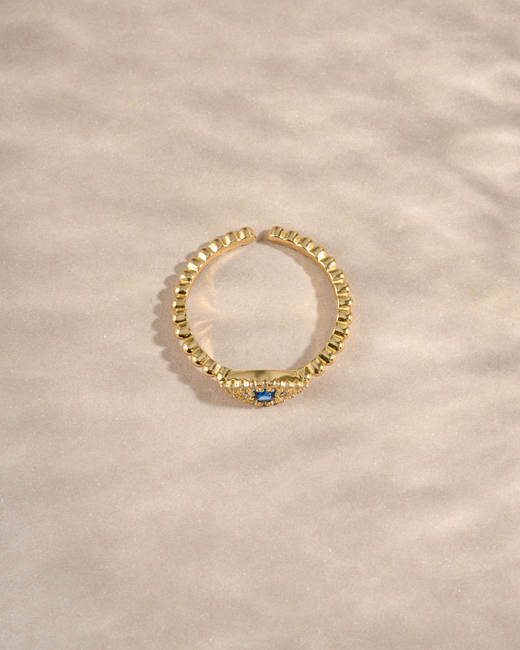 adjustable evil eye ring in gold top view showcasing adjustable fit