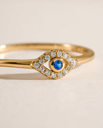 Close-up of a tiny blue evil eye ring by Samijewels-527, featuring a gold band and detailed blue evil eye charm.