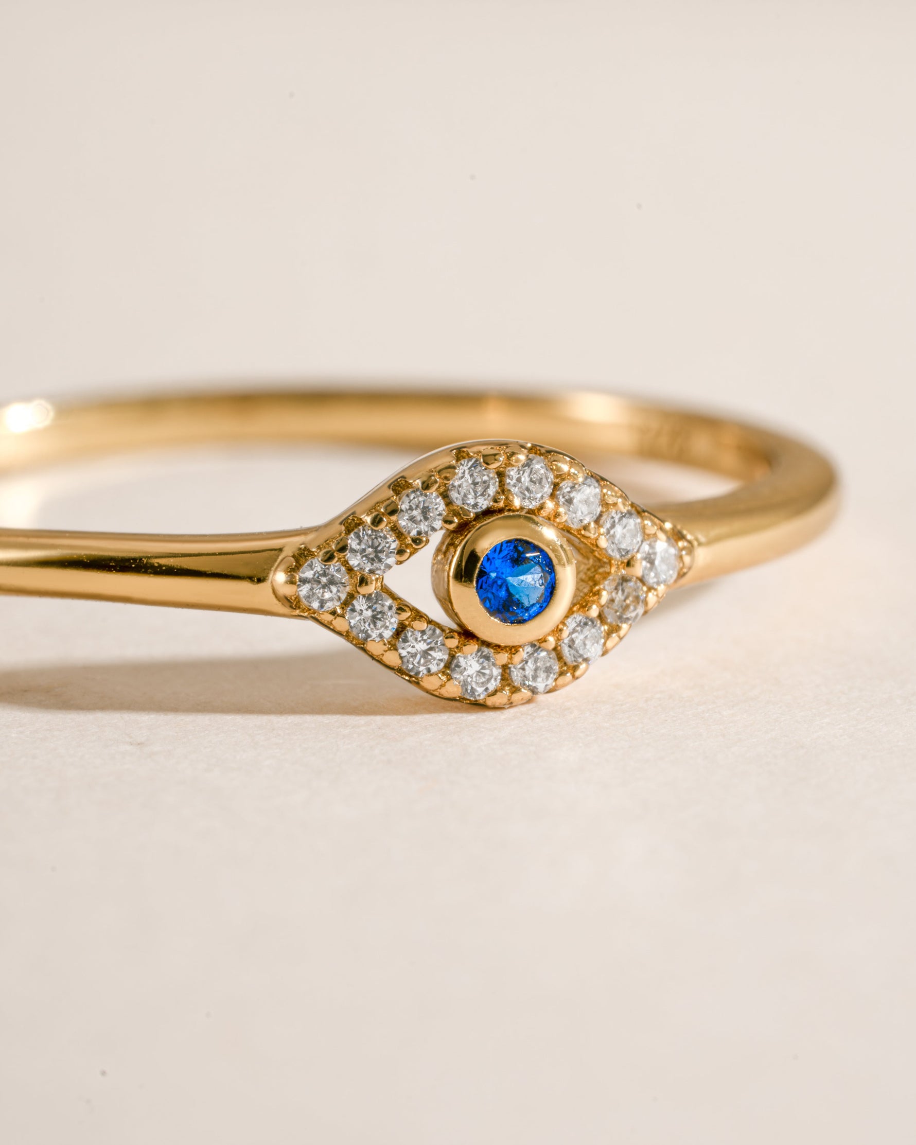 Close-up of a tiny blue evil eye ring by Samijewels-527, featuring a gold band and detailed blue evil eye charm.