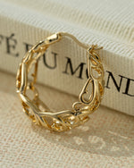 Close-up of gold filigree tapered hoop earrings by Sami Jewels, showcasing intricate metalwork and elegant design.