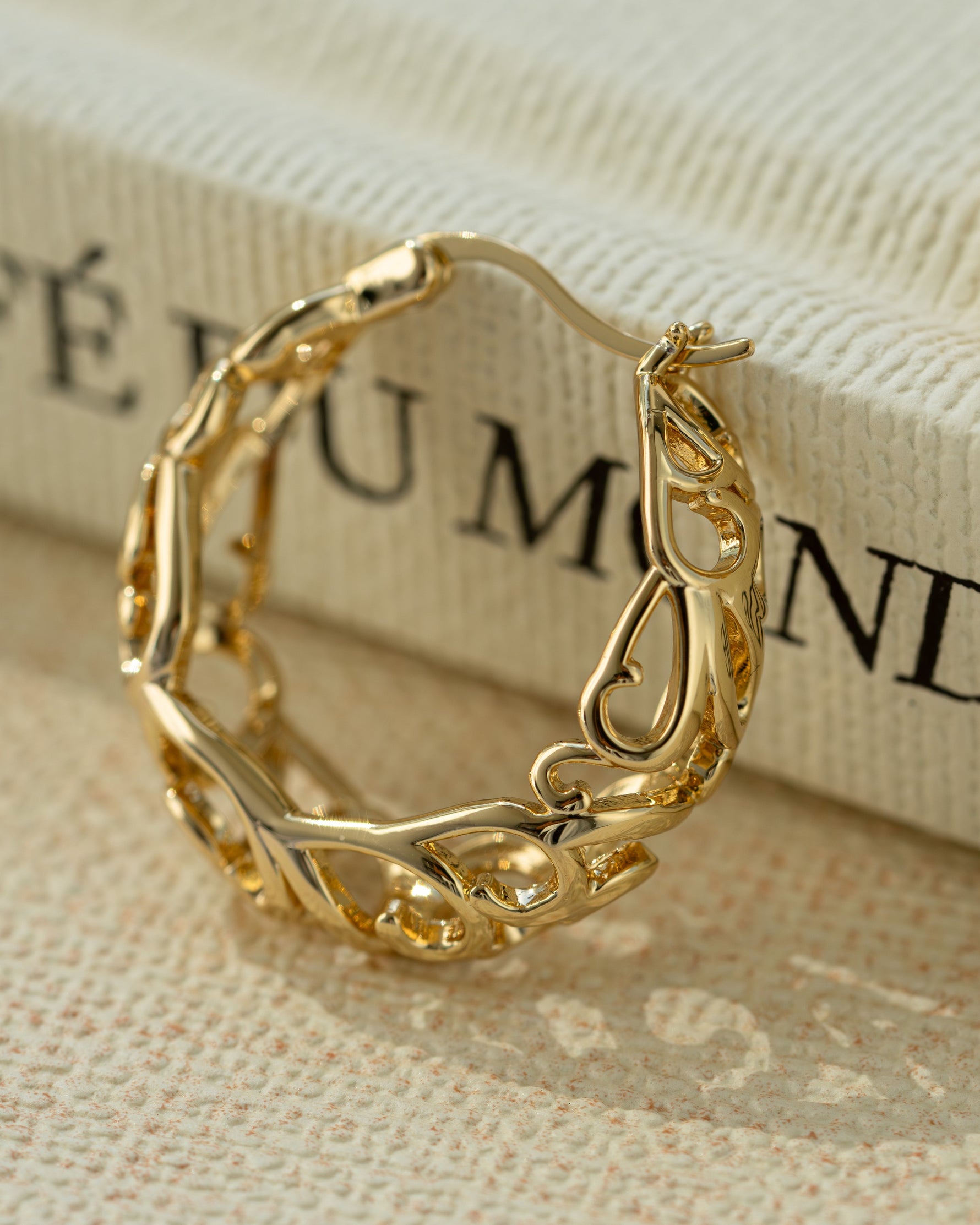 Close-up of gold filigree tapered hoop earrings by Sami Jewels, showcasing intricate metalwork and elegant design.