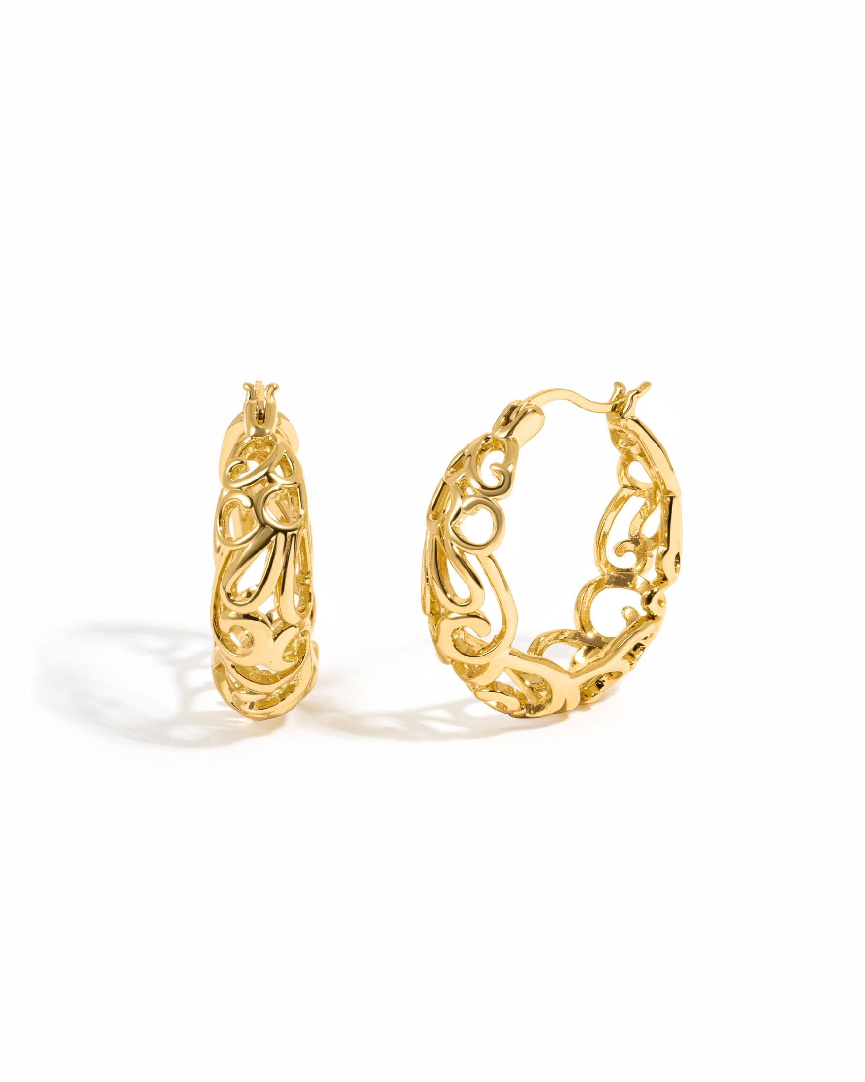 Gold filigree tapered hoop earrings by Sami Jewels with intricate detailed design on a white background.