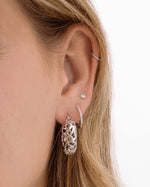 Silver filigree tapered hoop earrings by Sami Jewels worn on a model, showcasing intricate metalwork and elegant design.