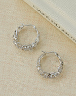 Silver filigree tapered hoop earrings by Sami Jewels worn on a model, showcasing intricate openwork design.
