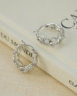 Silver filigree tapered hoop earrings by Sami Jewels featuring intricate lace-like metalwork and a sleek, elegant design.