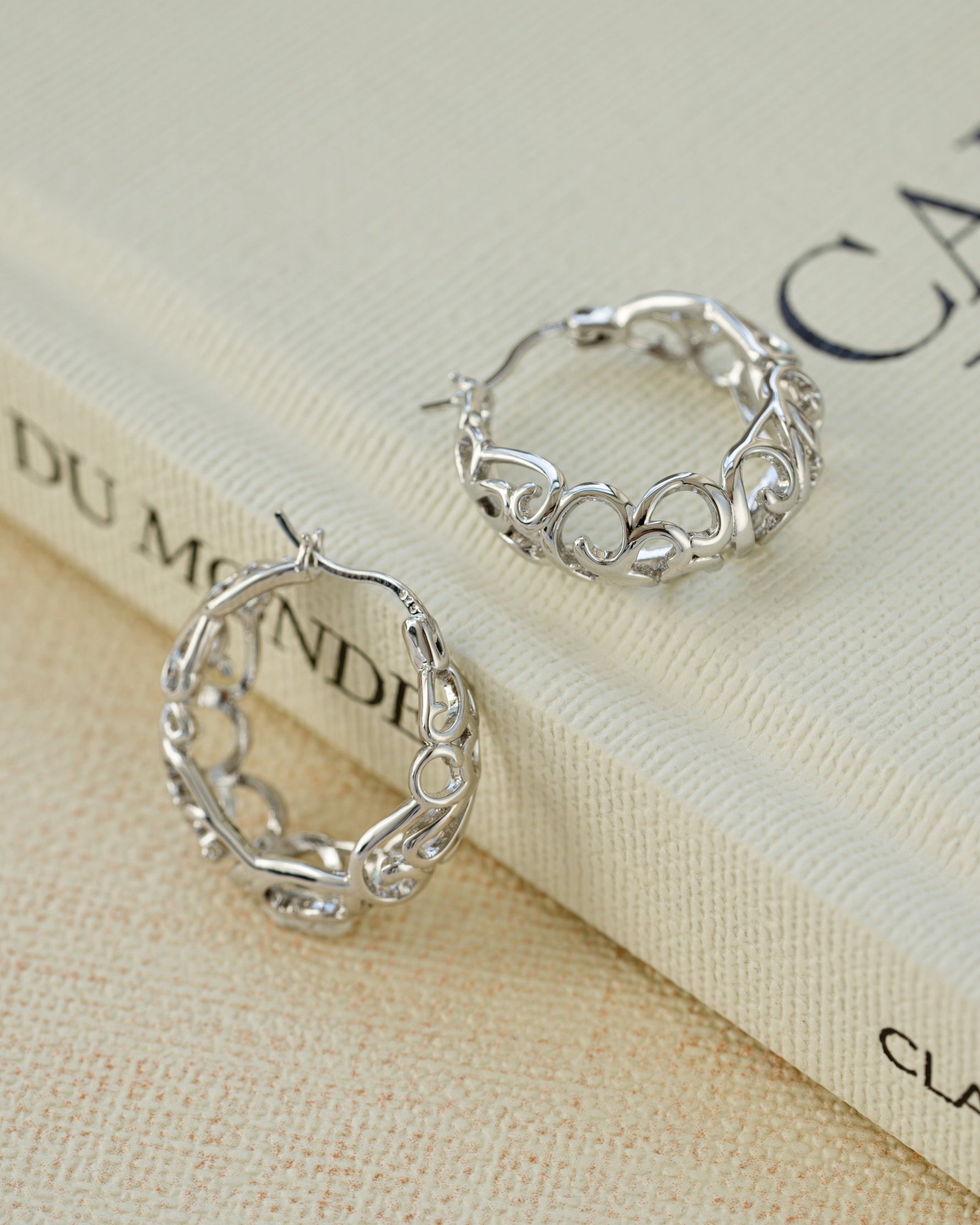 Silver filigree tapered hoop earrings by Sami Jewels featuring intricate lace-like metalwork and a sleek, elegant design.