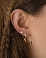 Gold 18mm flat hoop earrings by Sami Jewels, showcasing a stylish, minimalist design worn by a model.
