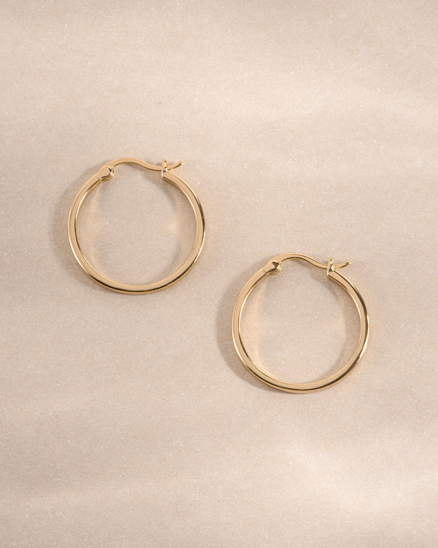 Gold 18mm flat hoop earrings by Sami Jewels featuring sleek, minimalist design with smooth, shiny surface.