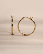 Gold 18mm flat hoop earrings by Sami Jewels, shown from the side view highlighting their sleek, minimalist design.