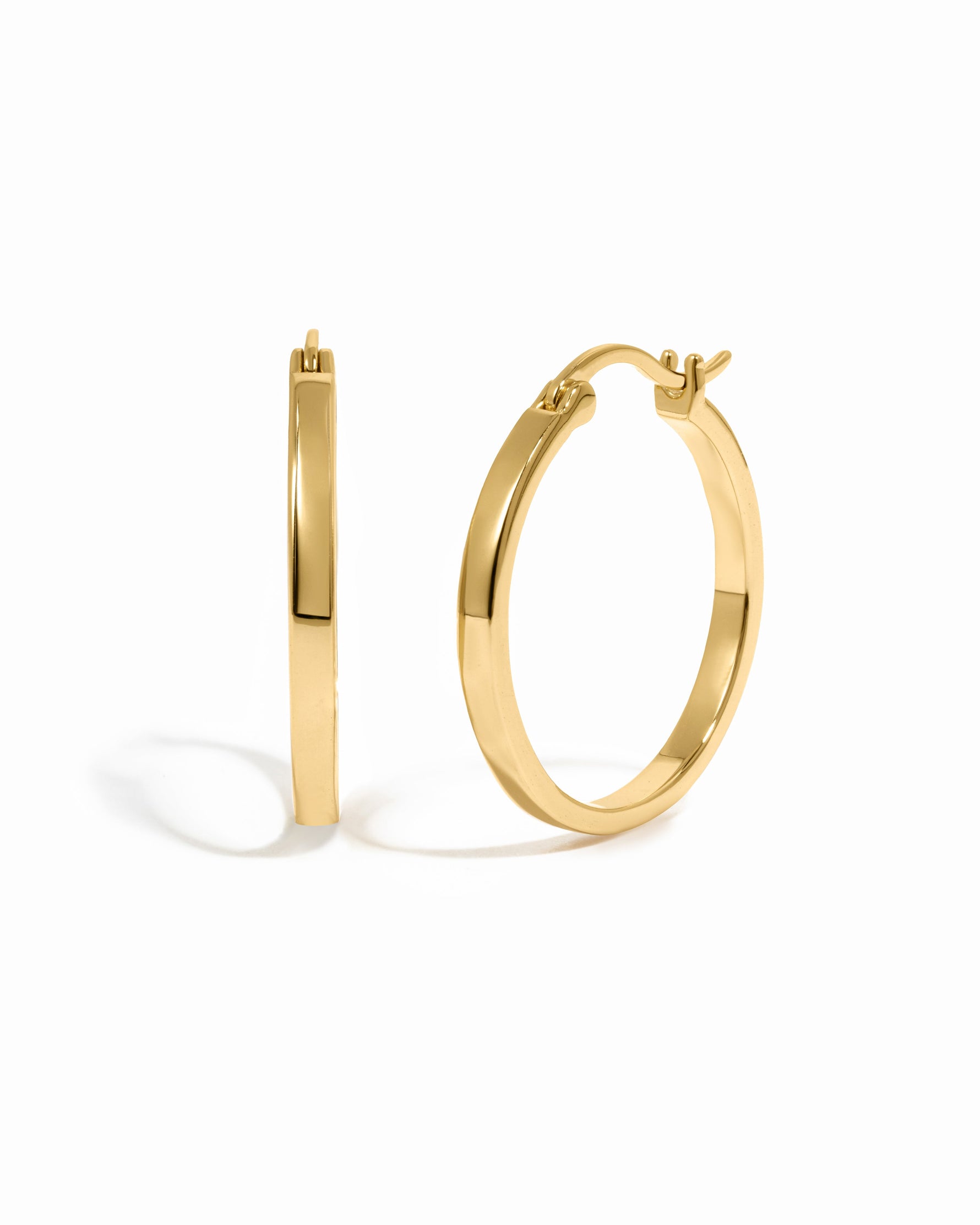 Gold 18mm flat hoop earrings from Sami Jewels displayed on a white background.