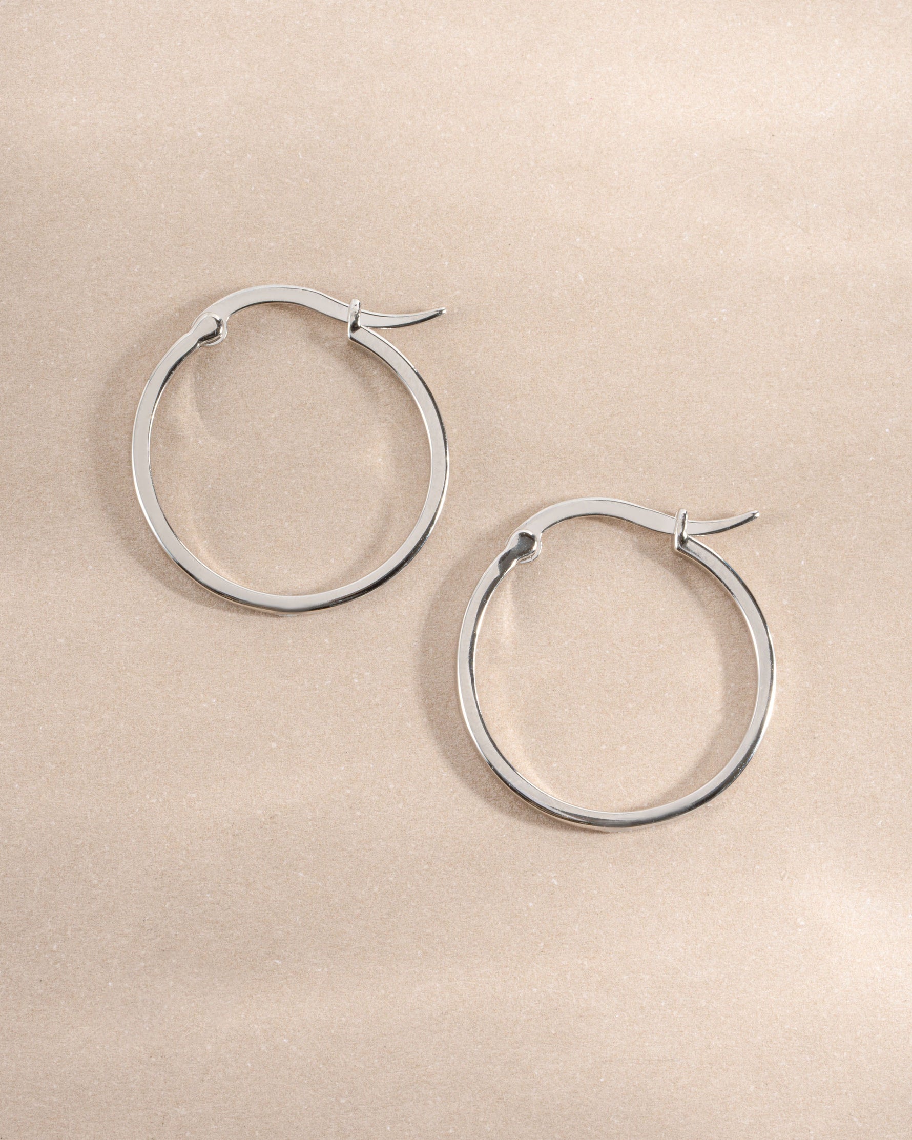 Sterling silver 18mm flat hoop earrings by Sami Jewels, showcasing sleek, minimalist design and polished surface.