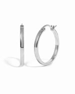 Sterling silver 18mm flat hoop earrings by Sami Jewels on a white background.