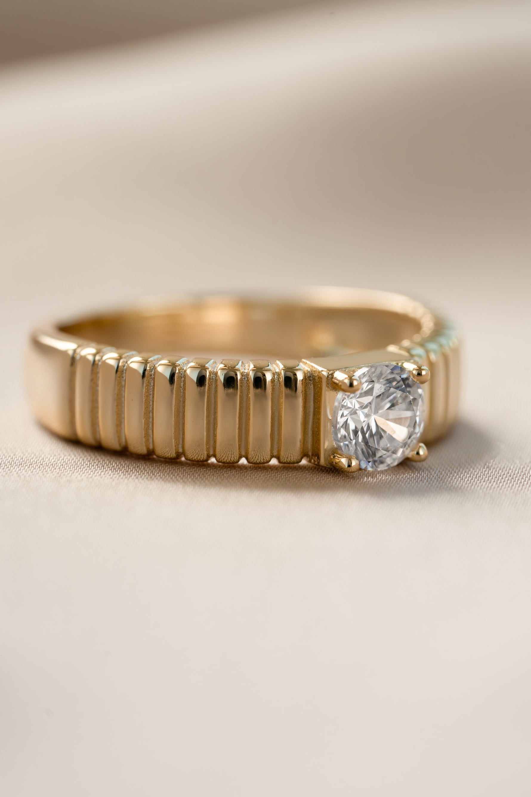 Gold fluted solitaire CZ ring from Sami Jewels, angled view showcasing the detailed band and sparkling central stone.