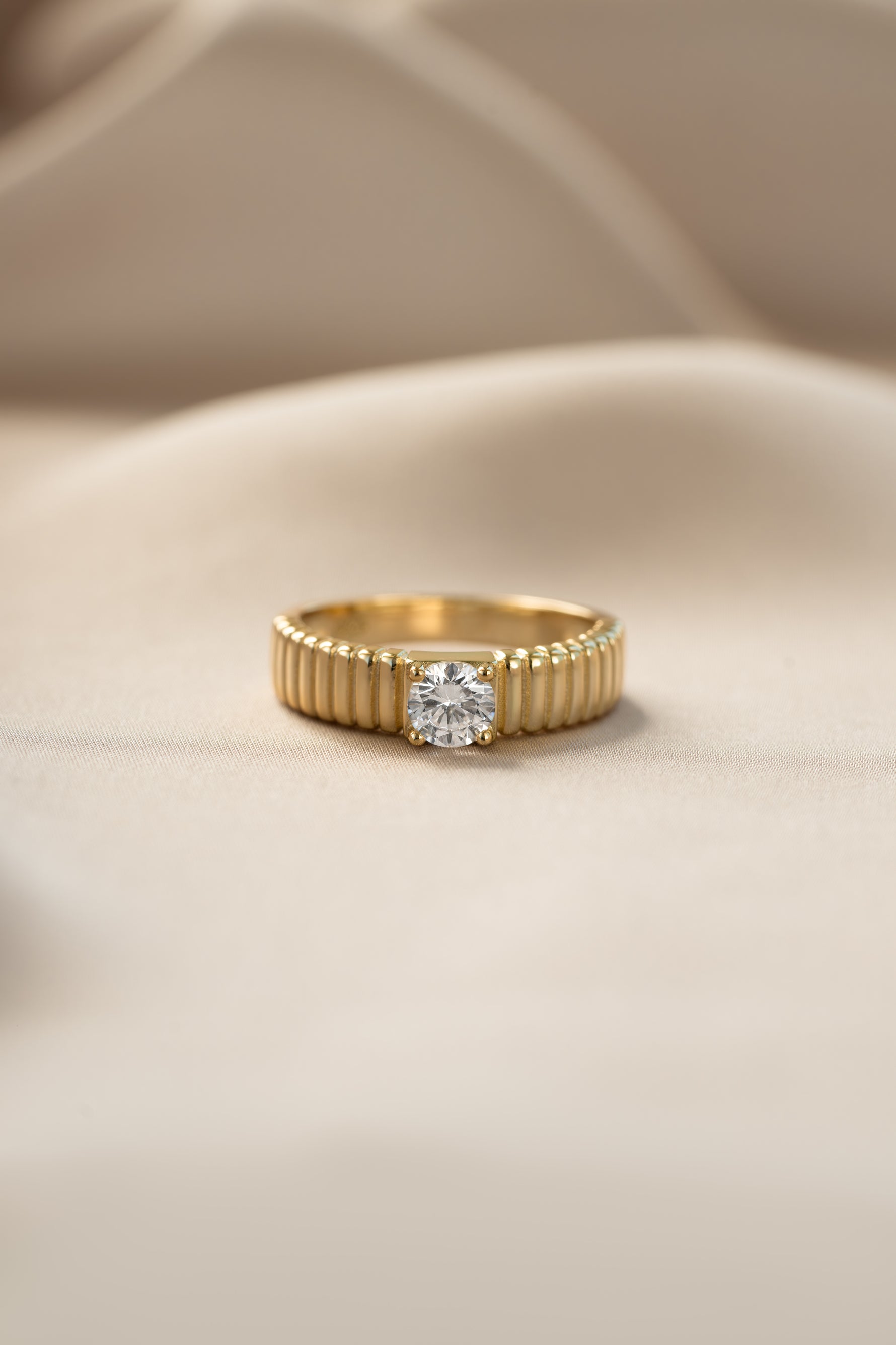Gold fluted solitaire CZ ring from Sami Jewels featuring a prominent central stone and intricate fluted band design.
