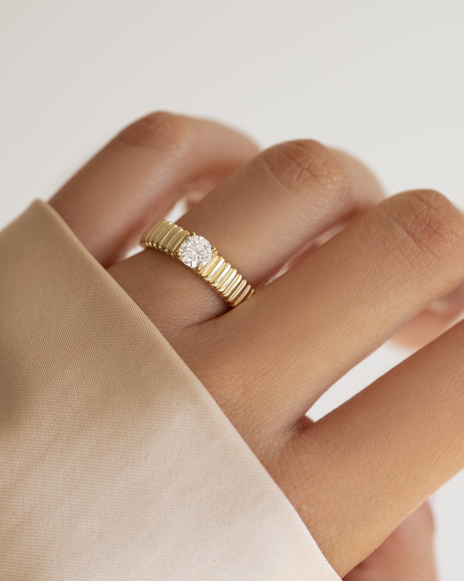 Gold fluted solitaire CZ ring by Sami Jewels featuring a prominent central stone and elegant band design.