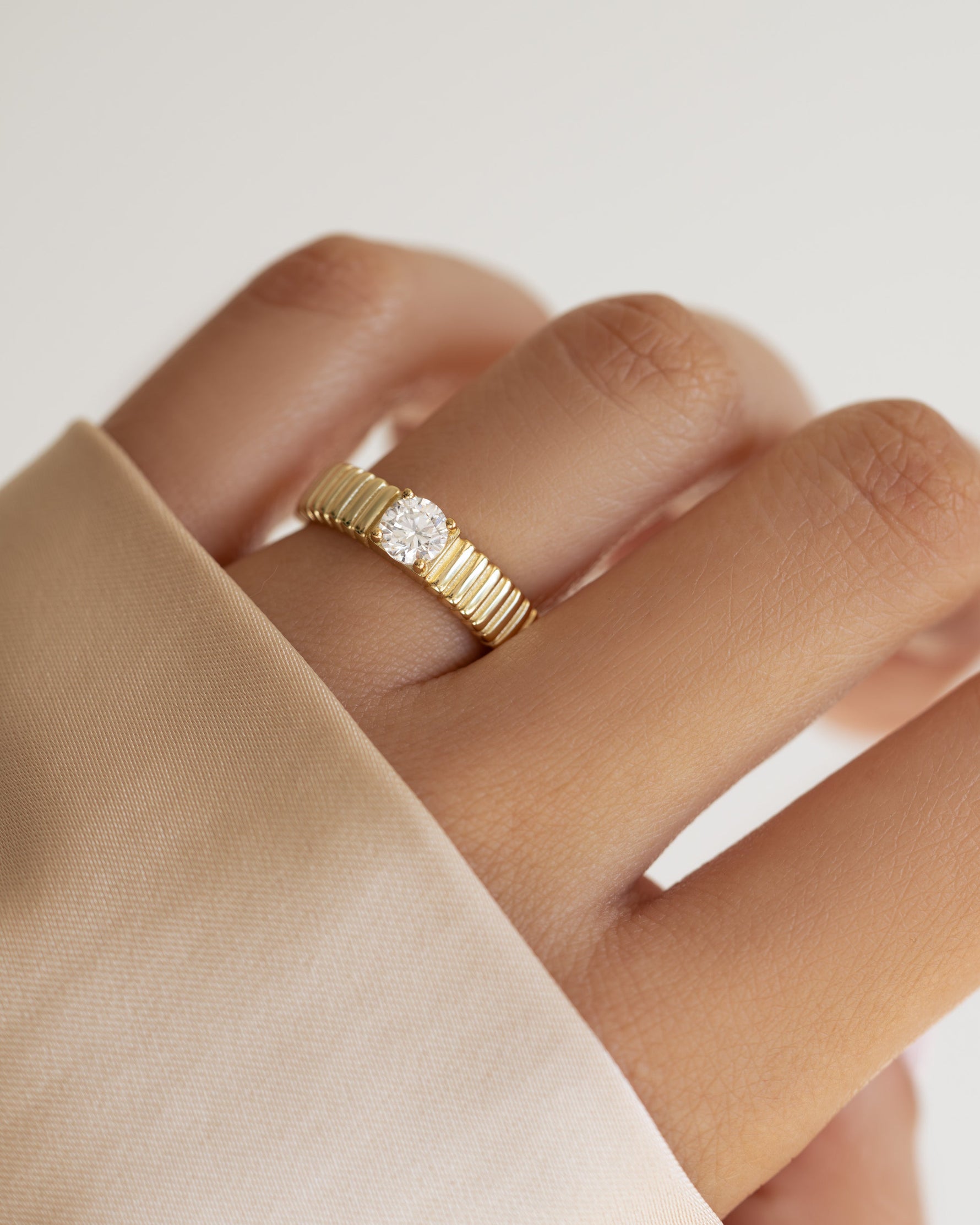 Gold fluted solitaire CZ ring by Sami Jewels featuring a prominent central stone and elegant band design.