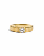 Gold fluted solitaire CZ ring by Sami Jewels with a smooth band and sparkling central stone on a white background.
