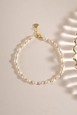 Freshwater pearl beaded bracelet by Sami Jewels featuring white pearls on a delicate gold chain, flat lay display.