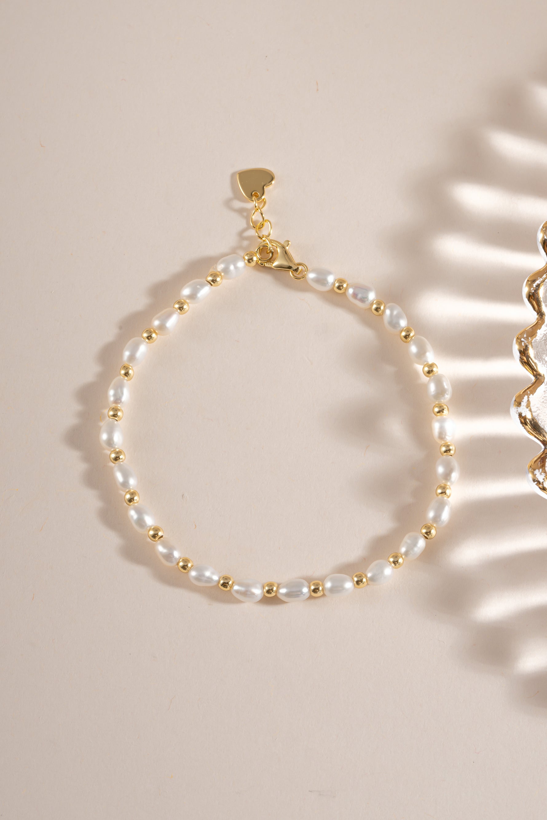 Freshwater pearl beaded bracelet by Sami Jewels featuring white pearls on a delicate gold chain, flat lay display.