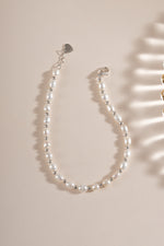 Freshwater pearl beaded bracelet by Sami Jewels featuring elegant white pearls and sterling silver accents, laid flat.