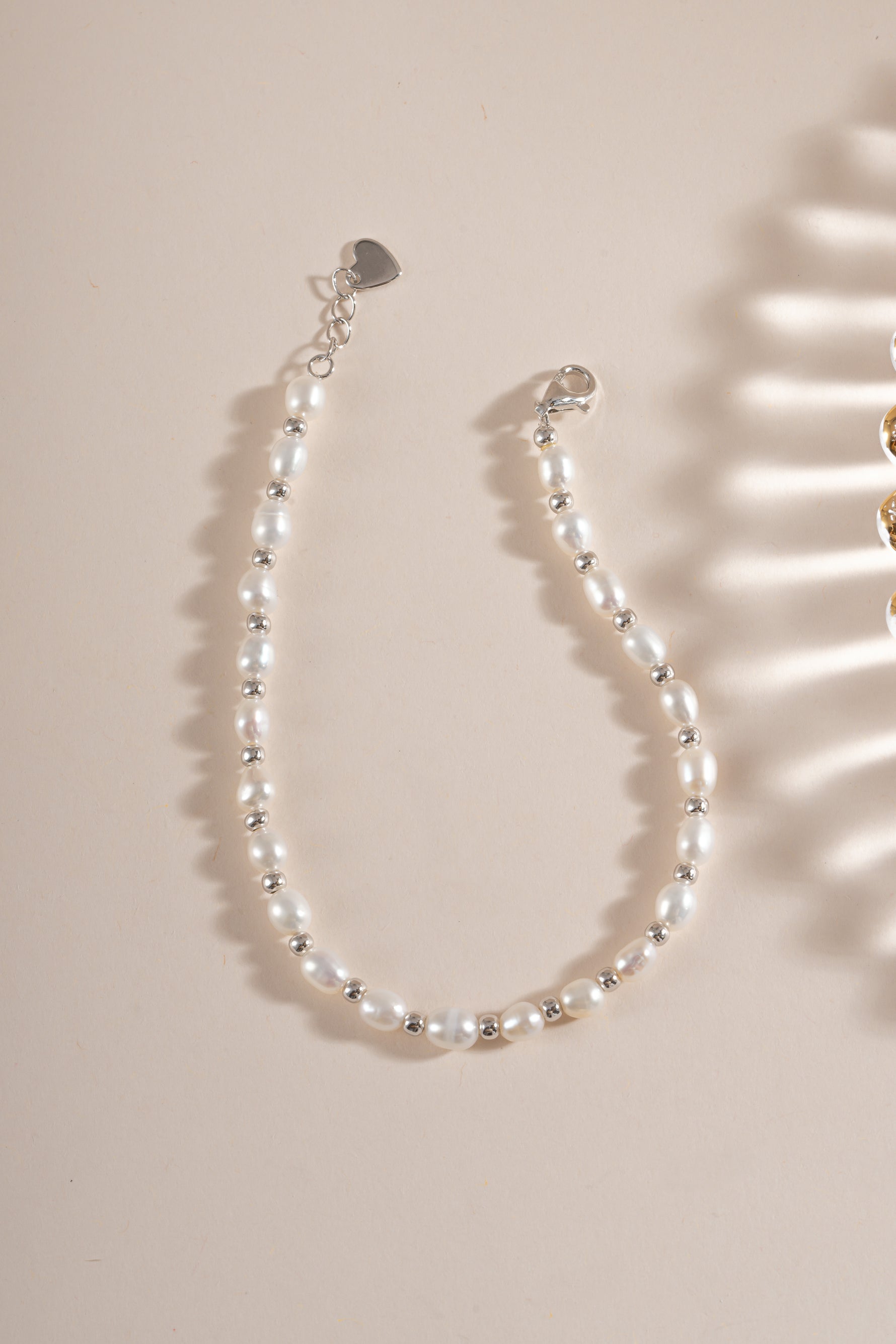 Freshwater pearl beaded bracelet by Sami Jewels featuring elegant white pearls and sterling silver accents, laid flat.