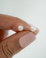 Close-up of Sami Jewels freshwater pearl stud earrings with gold setting, showcasing their elegant round pearl design.