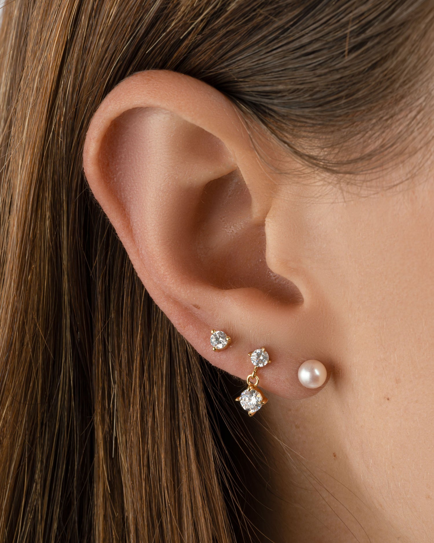 Gold freshwater pearl stud earrings by Sami Jewels featuring classic round pearl designs on a sleek gold setting.