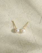 Gold freshwater pearl stud earrings by Sami Jewels, round pearl design, top view showcasing elegant jewelry detail