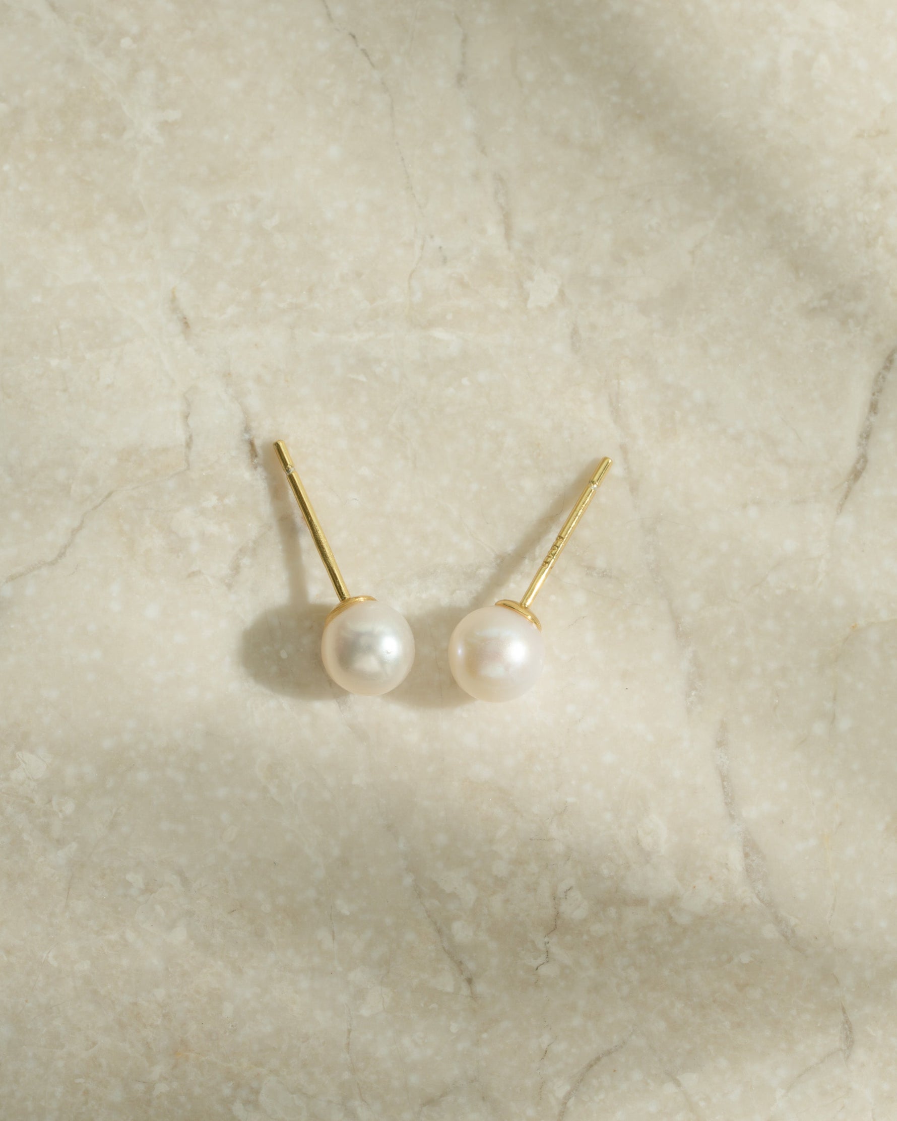 Gold freshwater pearl stud earrings by Sami Jewels, round pearl design, top view showcasing elegant jewelry detail