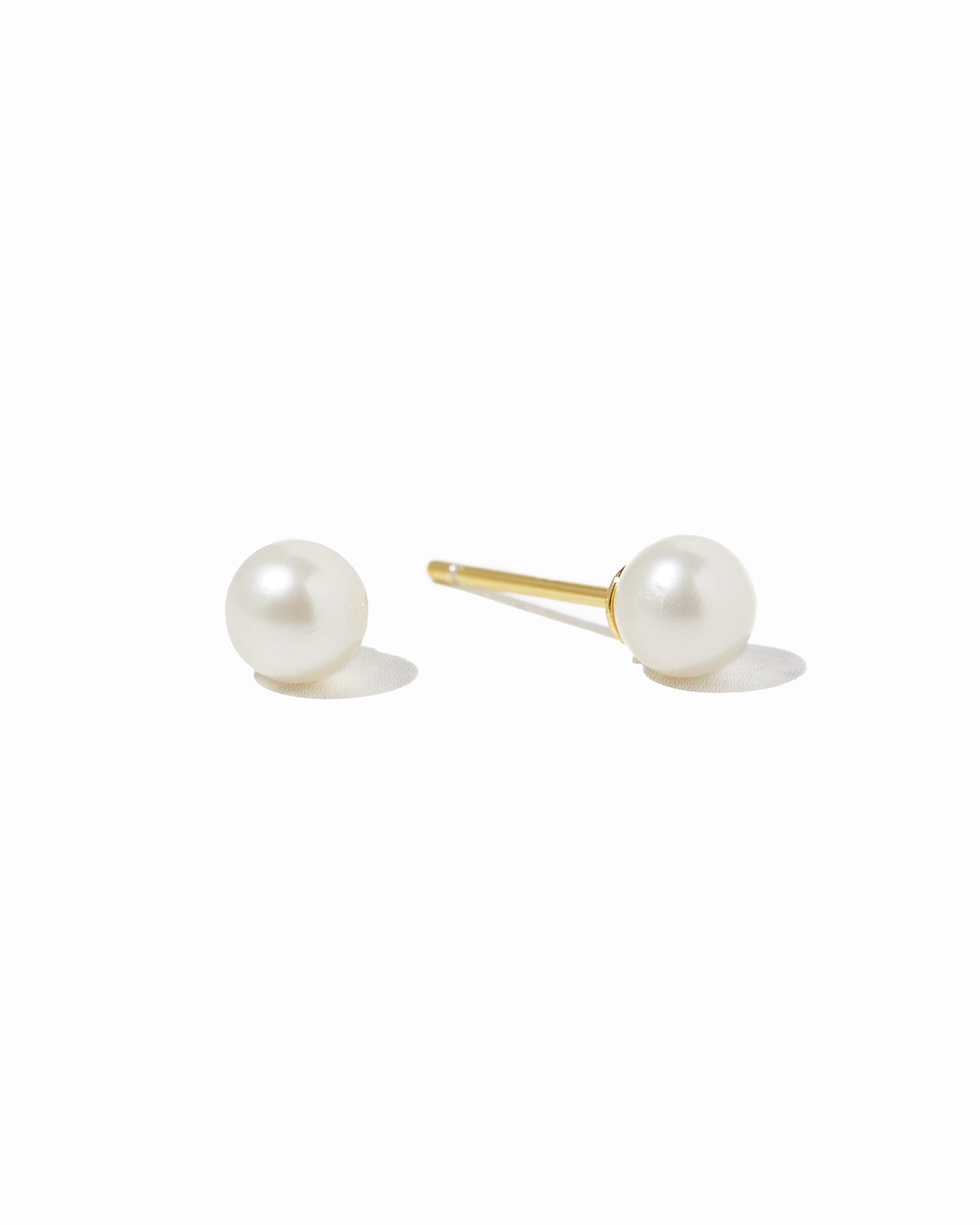 Freshwater Pearl Stud Earrings by Sami Jewels featuring white pearls on gold posts, displayed against a white background.