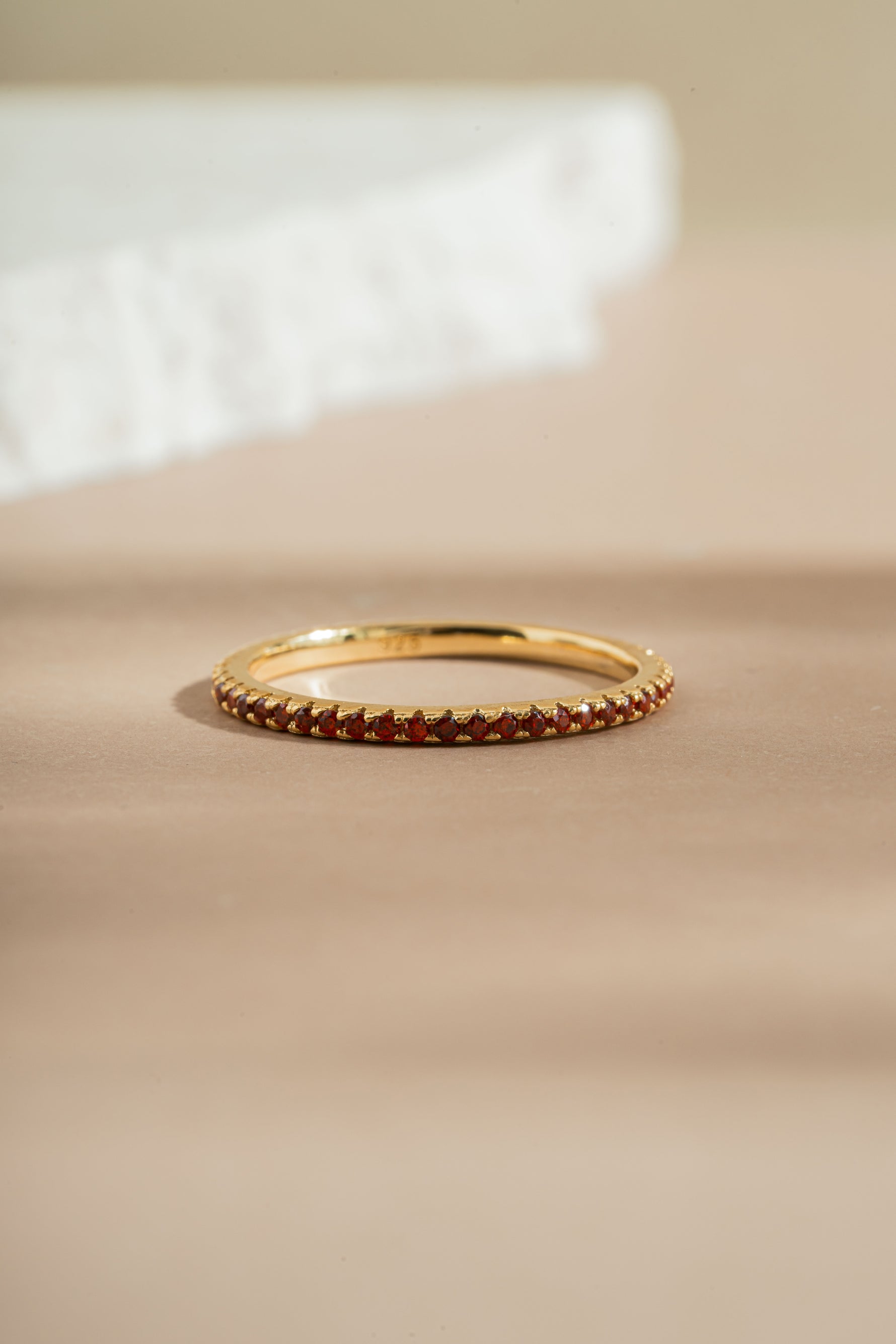garnet birthstone eternity ring neutral background