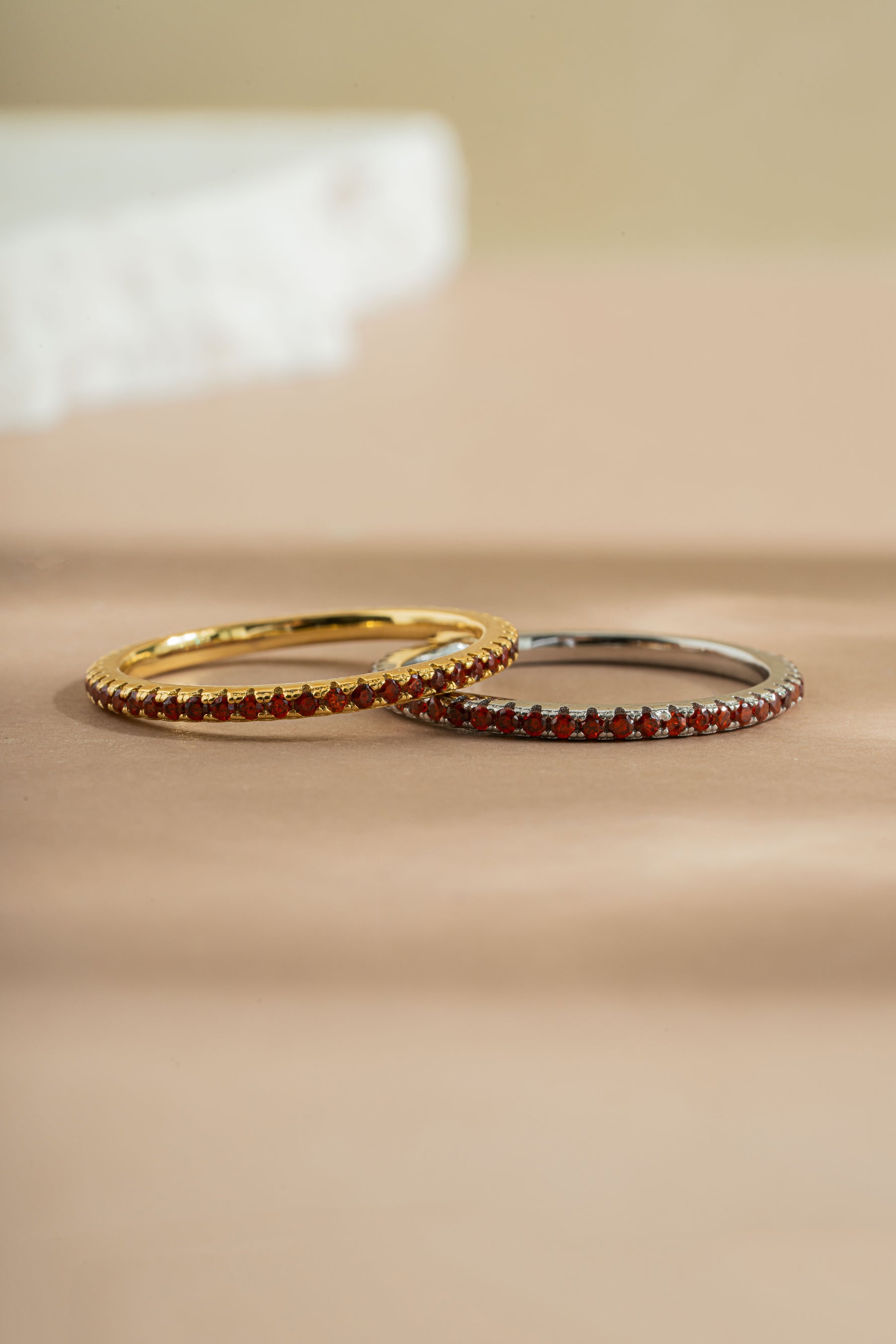 gold and sterling silver garnet birthstone eternity rings neutral background