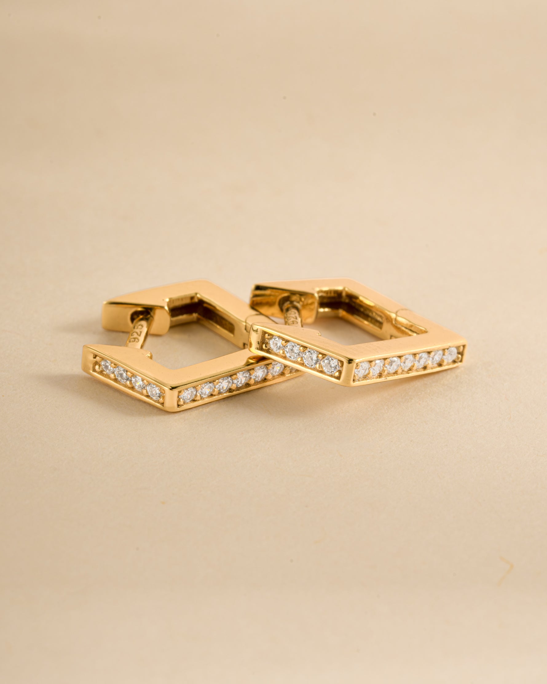 Close-up of gold geometric huggie earrings by Sami Jewels, showcasing their modern, angular design and polished finish.