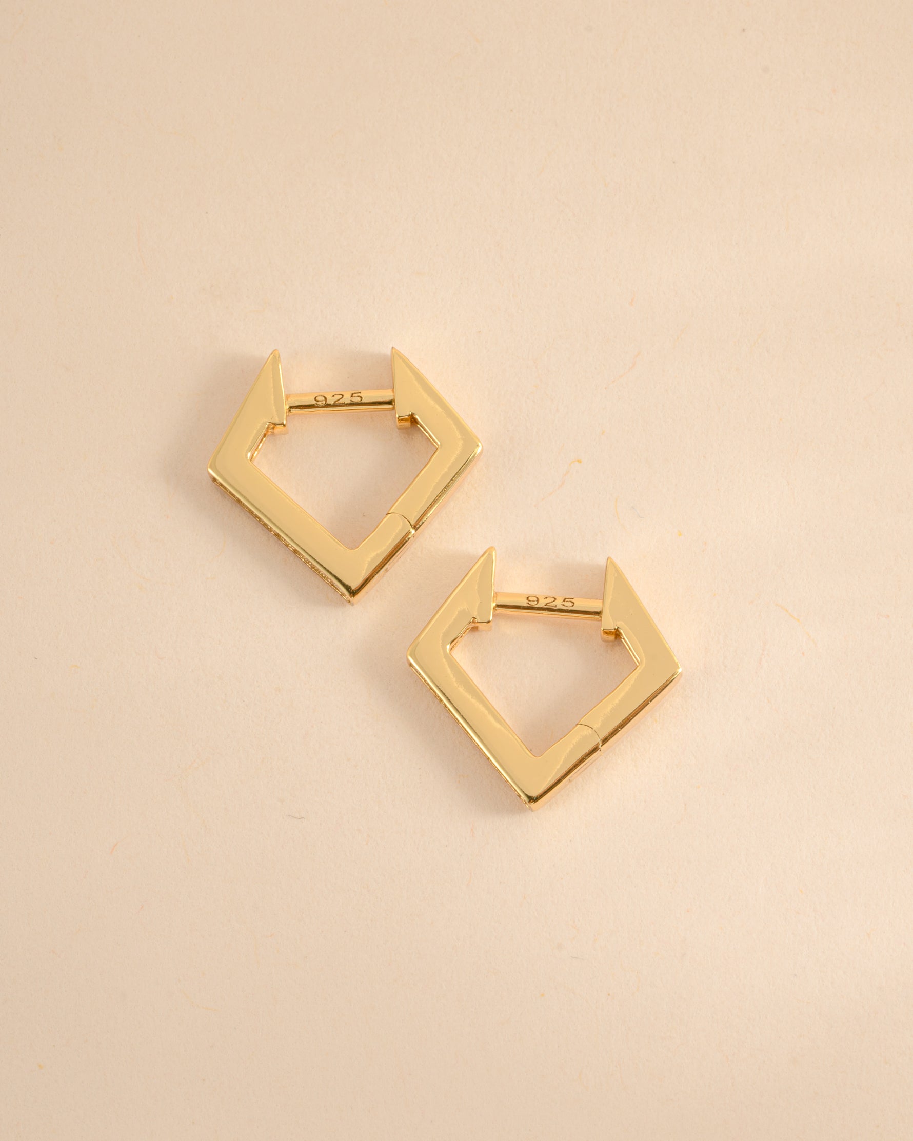 Gold geometric huggie earrings from Sami Jewels shown in side profile view, featuring modern angular design.